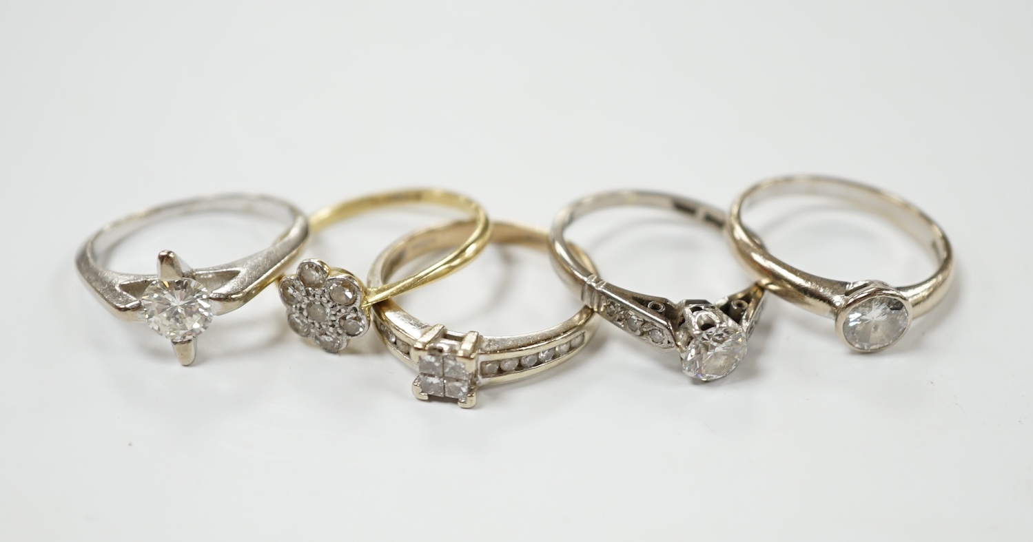 Four assorted 18ct, plat and diamond rings, including two solitaires and a flower head cluster, together with a modern 9ct and diamond cluster ring. Condition - fair